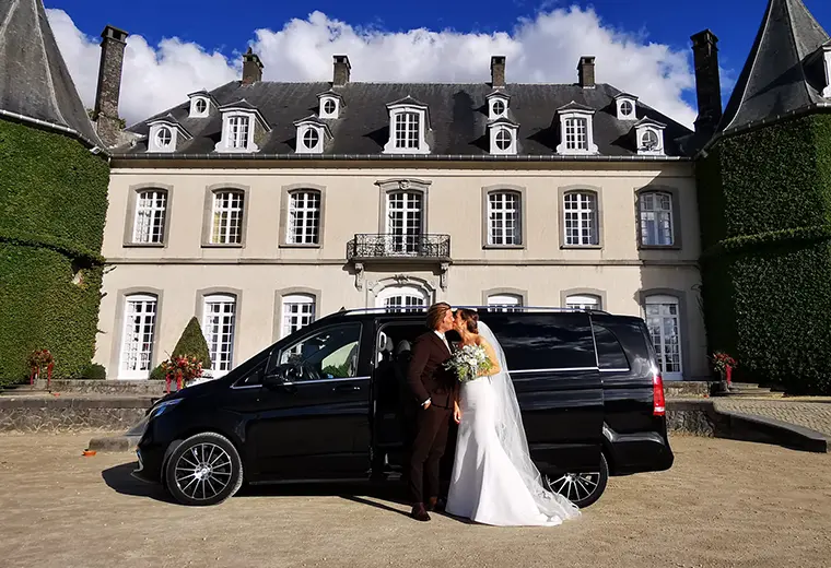 Couple devant un minivan devant un château